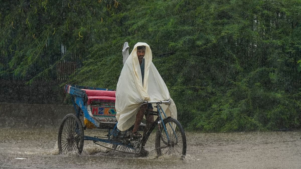 A rickshaw puller rides past during heavy monsoon rainfall near Yamuna Bazar area, in New Delhi. Credit: PTI Photo