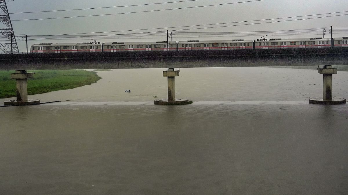 A Delhi Metro train passes by above the Yamuna river during heavy monsoon rainfall, in New Delhi. Credit: PTI Photo