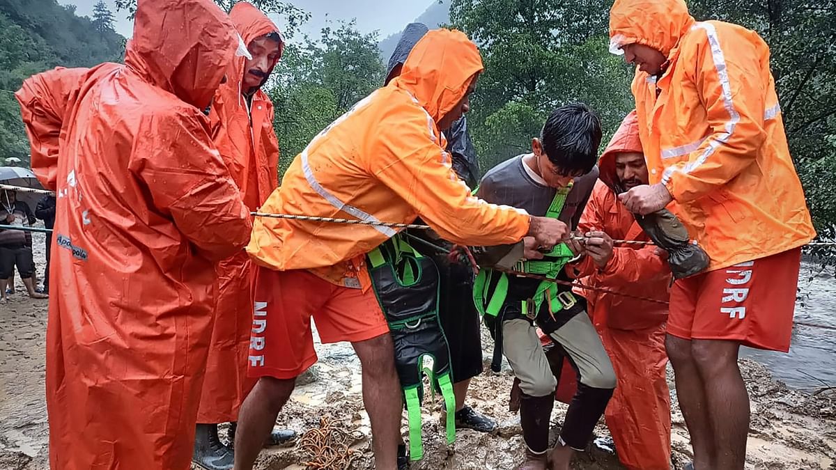 National Disaster Response Force (NDRF) personnel rescue a child amid flash floods due to heavy monsoon rainfall, in Kullu. Credit: PTI Photo