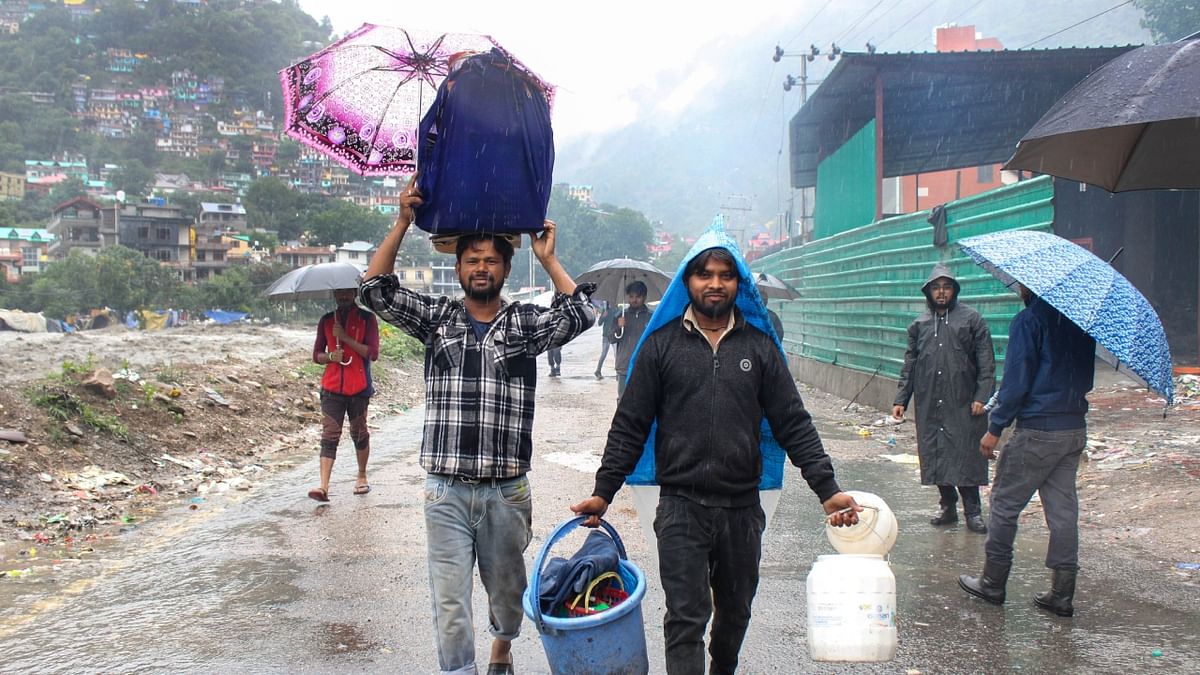 Locals move to a safer place amidts heavy rainfall, in Kullu. Credit: PTI Photo