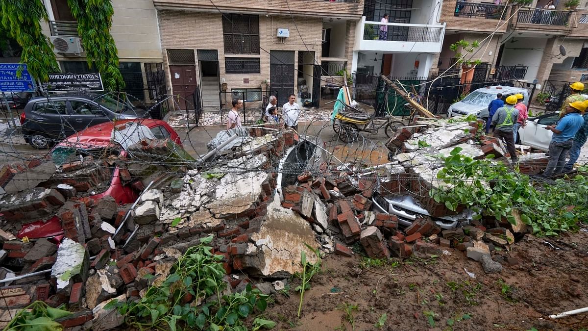 Vehicles damaged after a wall of Deshbandhu College collapsed following monsoon rains, in New Delhi. Credit: PTI Photo