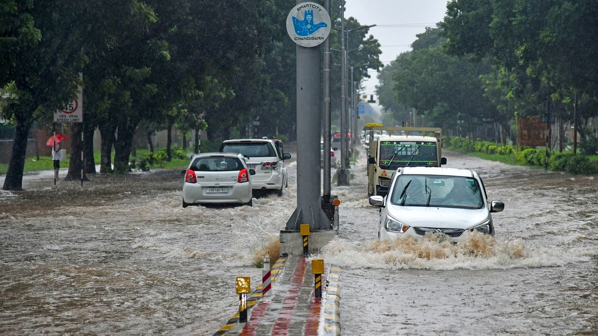 Vehicles make their way on a waterlogged road amid heavy monsoon rains in Chandigarh. Credit: PTI Photo