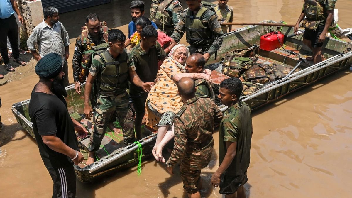 Indian Army personnel rescue people stuck in a flooded residential area after an increase in the water level of Badi Nadi river following heavy monsoon rain, in Patiala. Credit: PTI Photo