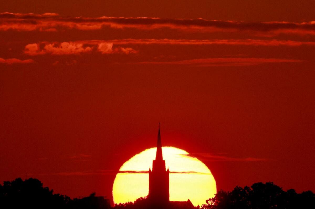 A church is pictured during sunset as a heat wave hits Europe, in Sancourt, France. Credit: reuters Photo
