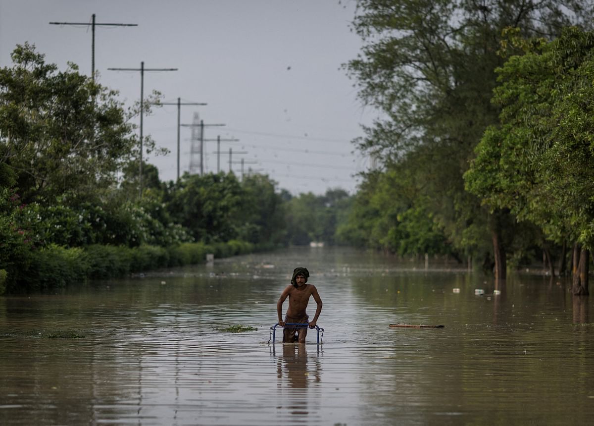 A man rides a cart on a flooded road behind the Red Fort after a rise in the water level of the river Yamuna after heavy monsoon rains. Credit: Reuters Photo