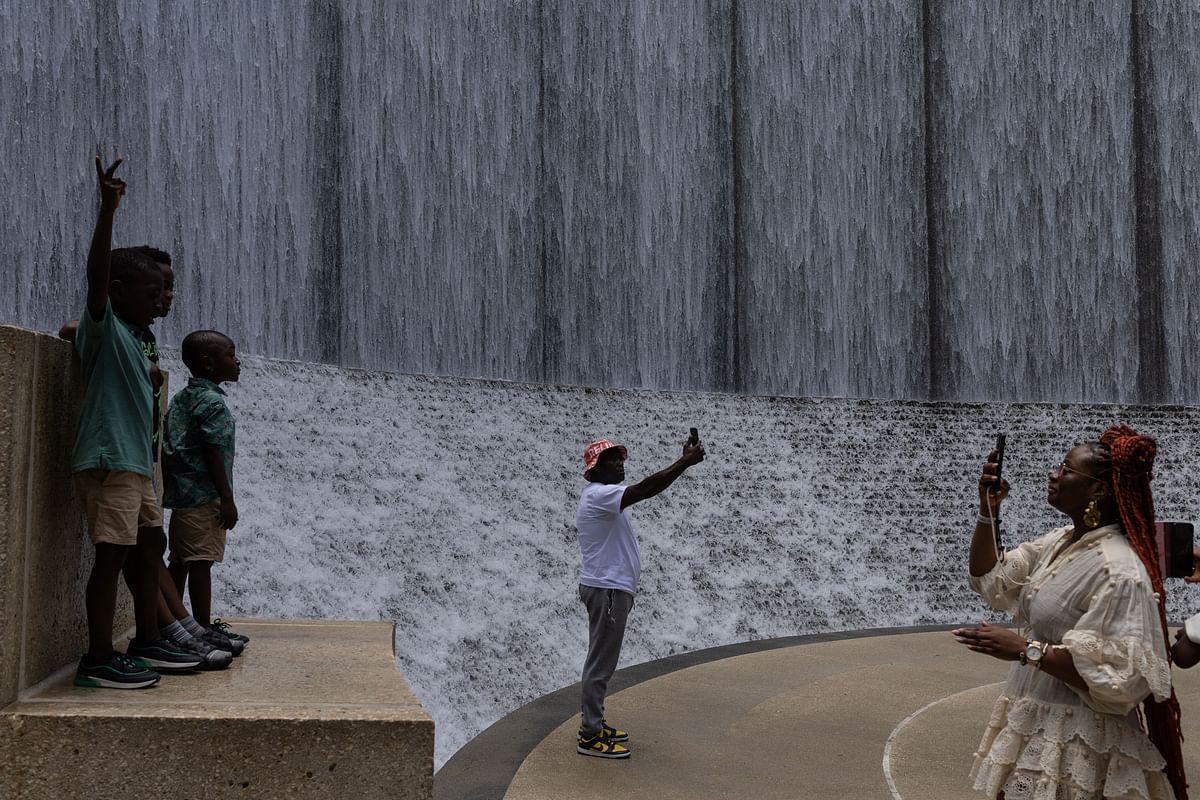 Tourists take photographs while visiting the Waterwall during hot weather in Houston, Texas. Credit: Reuters Photo