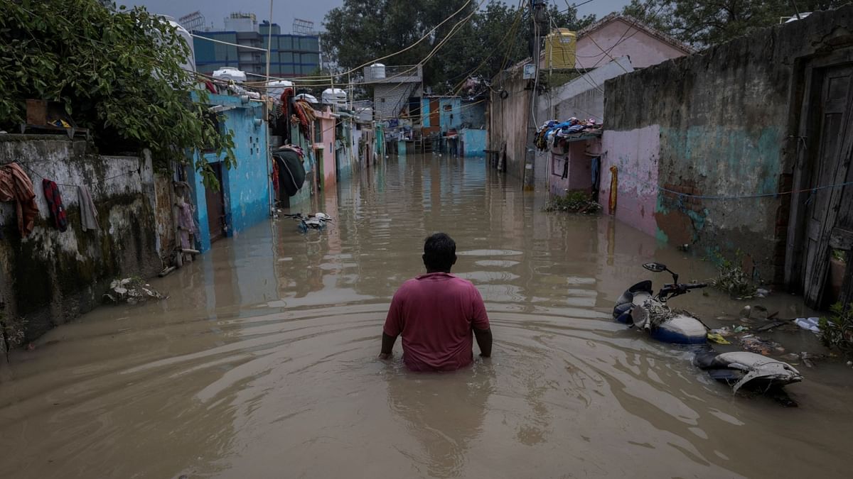 A man walks through a flooded alley at a residential colony, after water rose from the river Yamuna due to heavy monsoon rain, in New Delhi. Credit: Reuters Photo