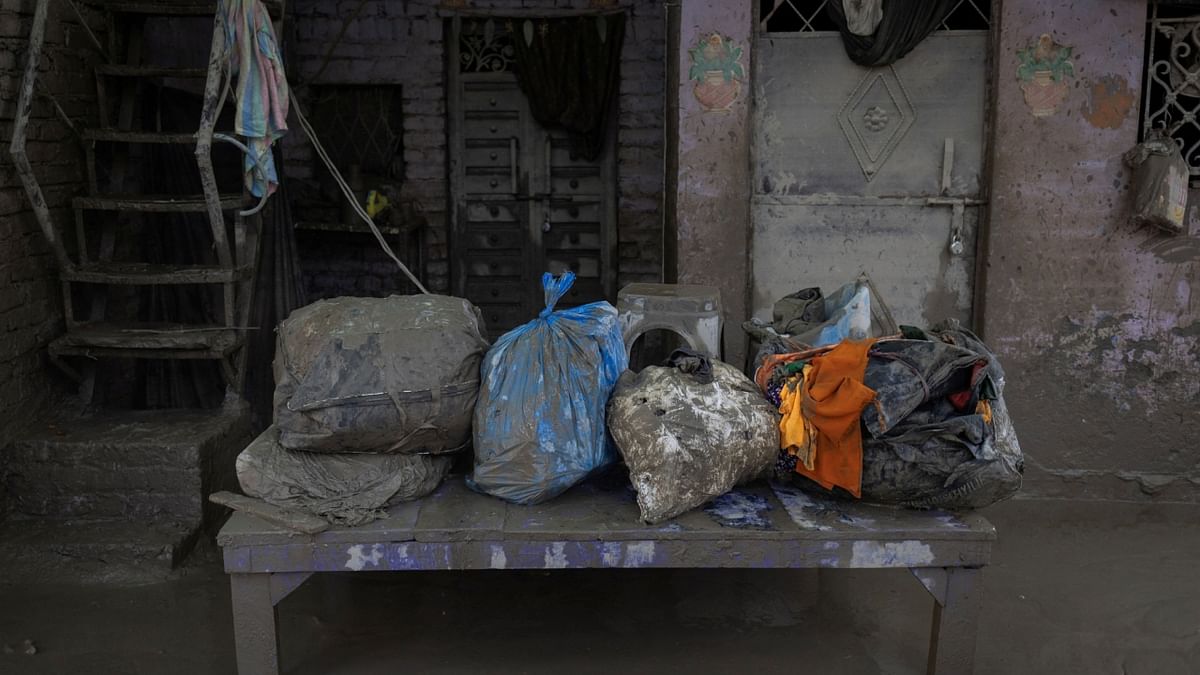 Muddy bags filled with clothes are seen outside a house after flood water receded from a residential area in New Delhi. Credit: Reuters Photo