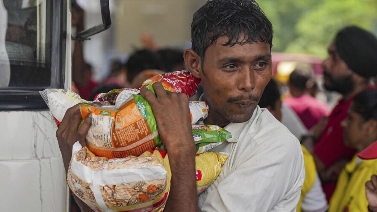 A man receives ration near the makeshift camps set up for the flood-affected people at Mayur Vihar area, in New Delhi, Wednesday, July 19, 2023. Credit: PTI Photo