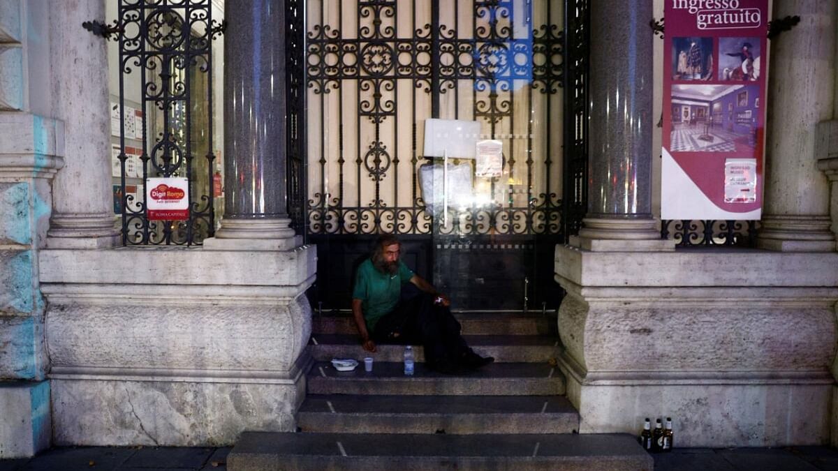 Steven from Croatia who is homeless and sleeps on the stairs of a museum looks on after he has been given a bottle of water, some pasta and cold tea by Red cross workers as they check on homeless, during a heatwave across Italy, in Rome, Italy. Credit: Reuters Photo