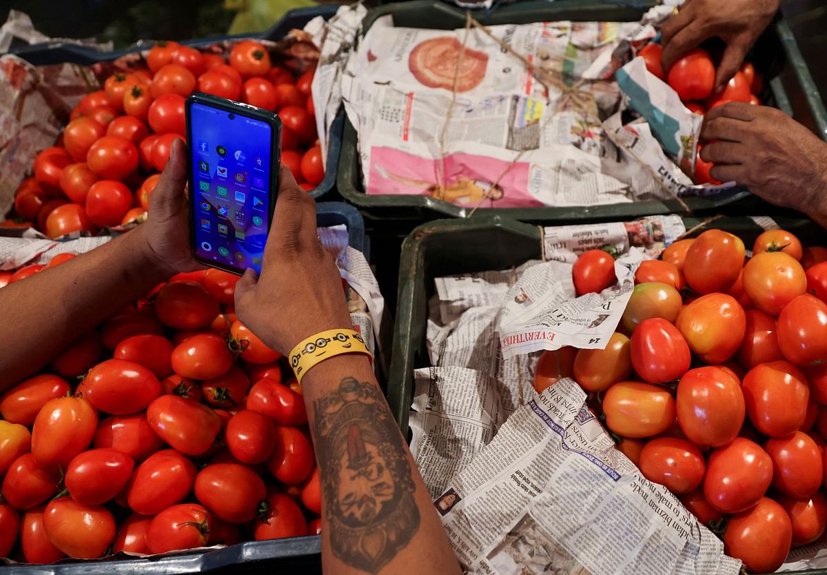 Tomatoes covered with newspapers are seen in baskets at a vegetable wholesale market in Navi Mumbai. Credit: Reuters Photo