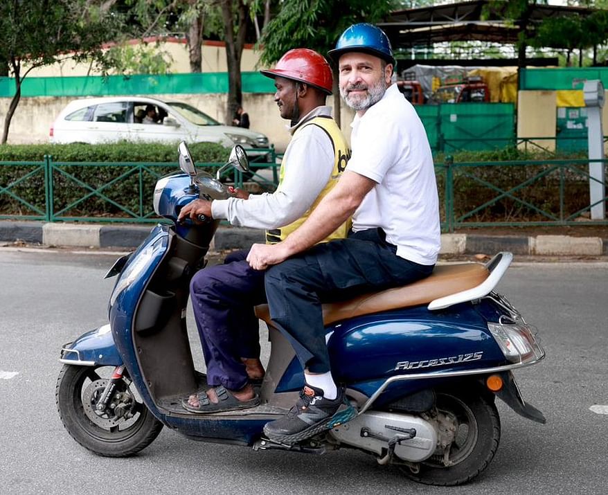 Congress leader Rahul Gandhi rides a scooter with a food delivery man, in Bengaluru. Credit: IANS Photo