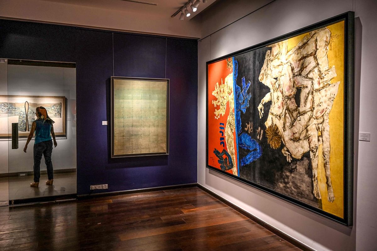 In this photo taken on February 24, a staff member walks past paintings displayed during a media preview at the Saffron Art Gallery in Mumbai on February 24, 2020, ahead of the Spring Live Auction being conducted by Saffronart on behalf of the Tax Recovery Officer of India's Income Tax Department. (Credit: AFP)