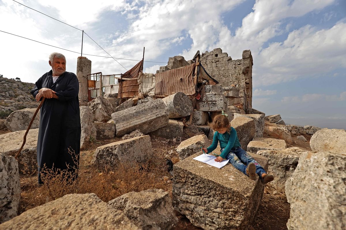 Displaced Syrians are pictured on November 1, 2020 at the UNESCO-listed site of Baqirha not far from the Turkish border, in a region of northwest Syria filled with abandoned Roman and Byzantine settlements. - Almost one million Syrians fled their homes last winter during a Russia-backed offensive on Syria's last rebel stronghold of Idlib, and dozens of them have settled in the UNESCO-listed site of Baqirha, near the Turkish border, among centuries-old Roman and Byzantine ruins. Credit: AFP Photo