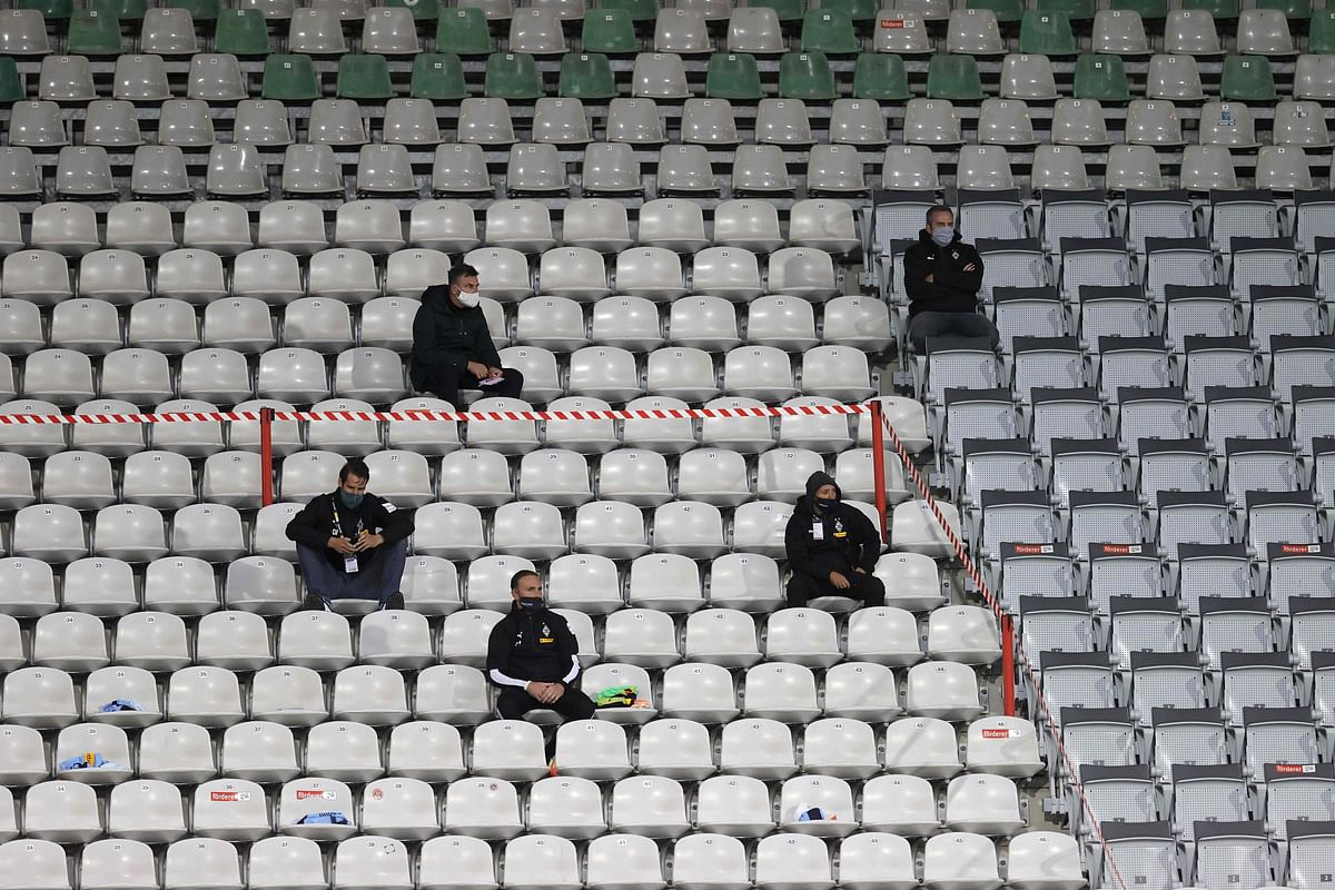 Team staff wearing protective face masks sit on the tribune during the German first division Bundesliga football match SC Freiburg v Borussia Moenchengladbach. Credit: AFP