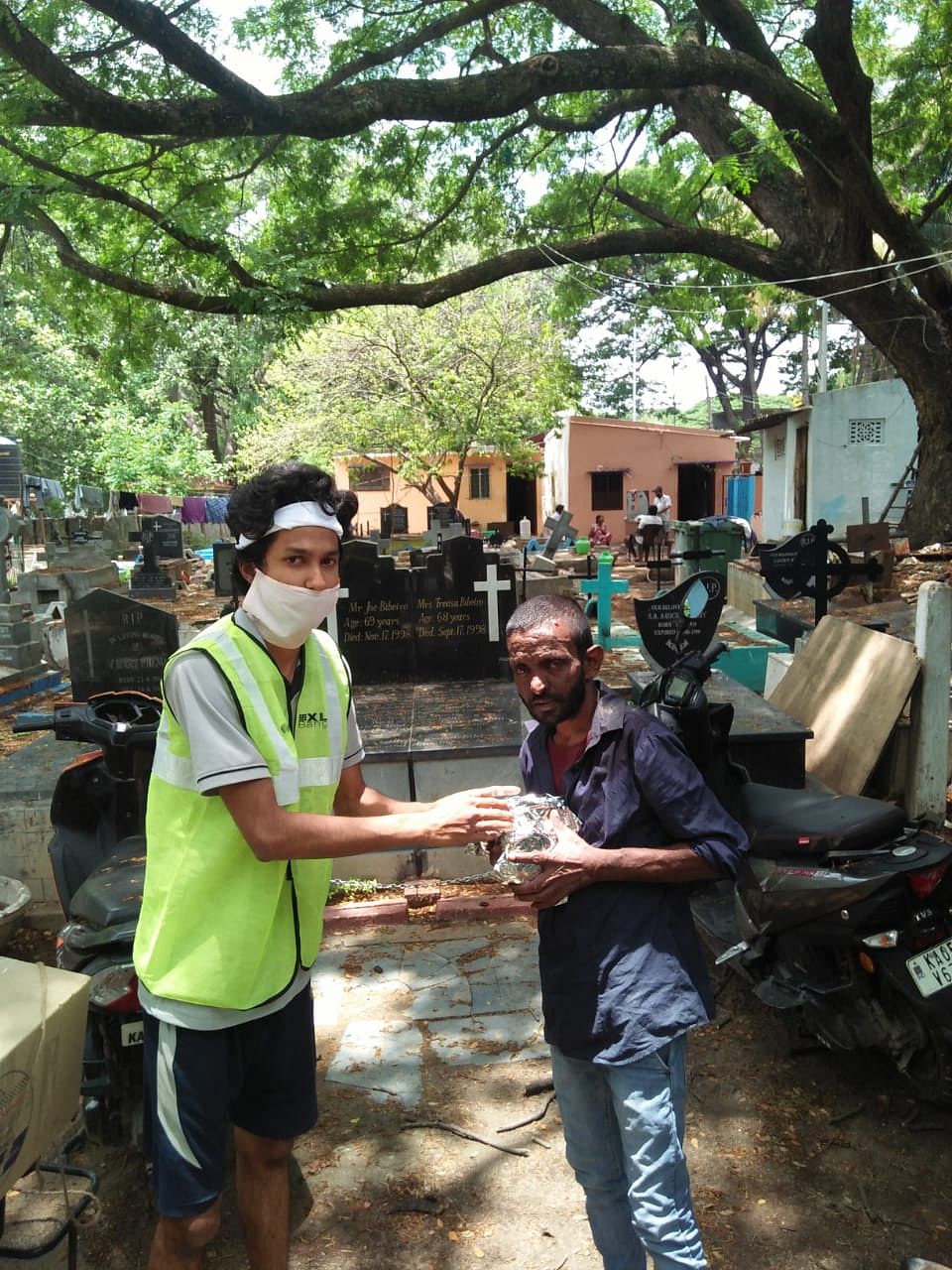 A member of the Covid Biker Relief Squad distributing food to a graveyard worker.