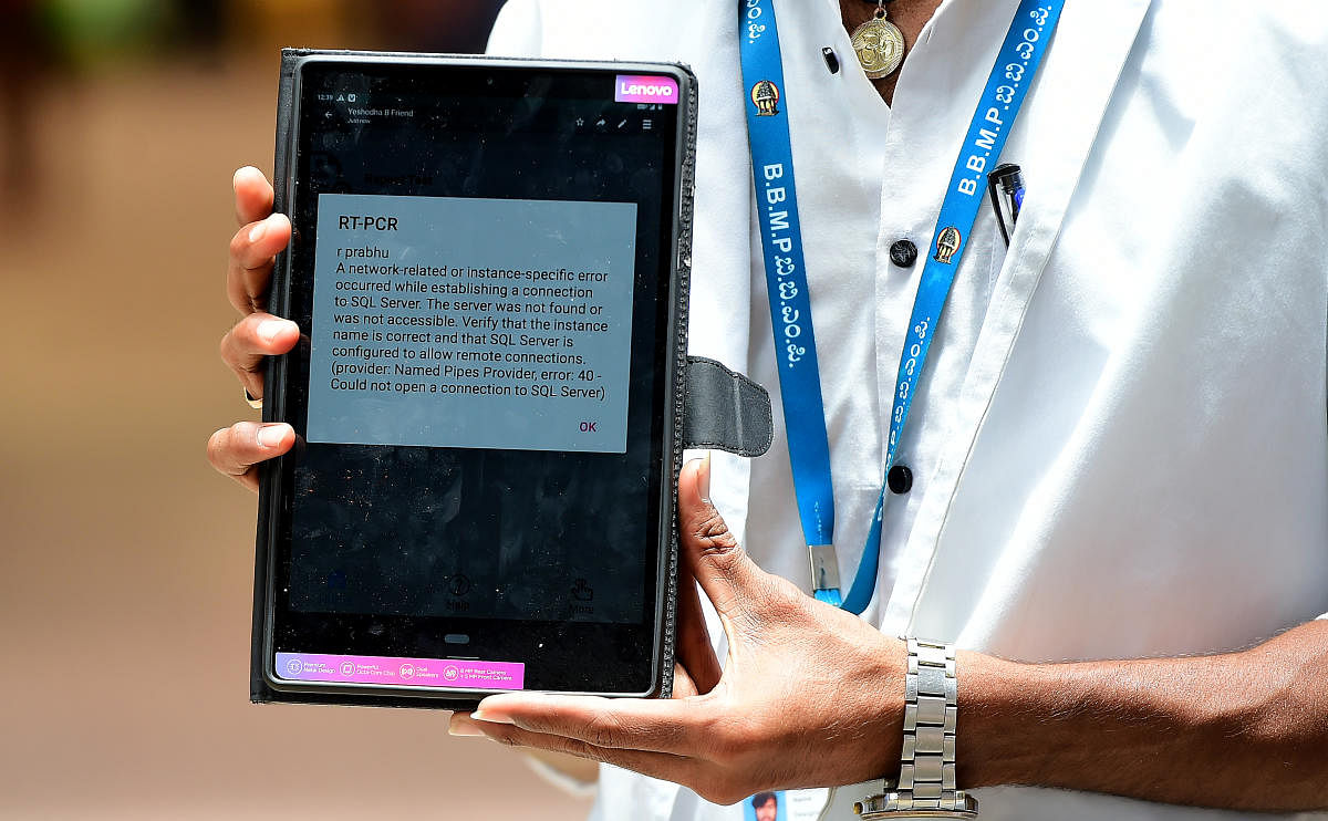A health worker showing the error message flashed from the server while uploading the testing details at KSR Railway Station. Due to the technical glitch, the personnel were unable to check the arriving returnees to Bengaluru. Credit: Ranju P