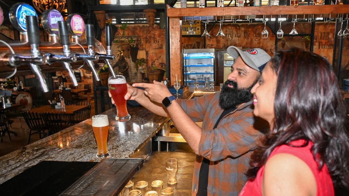 The author (in red) learns how to pour beer from the tap with the right amount of head. Credit: DH Photo
