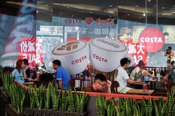 People sit on the terrace of an cafe of the British coffeehouse chain Costa Coffee in Beijing, China. Credit: Reuters