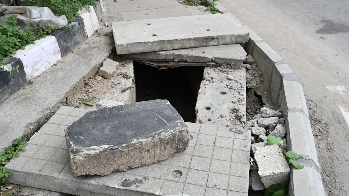 Open drain near Palace Guttahalli bus stop shabbily covered with slabs. Credit: DH Photo