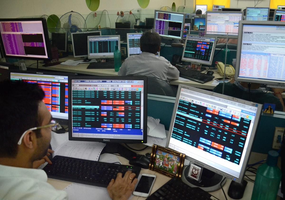 Kolkata: Sharebrokers and holders check the Sensex and Nifty at a Share market in Kolkata on Friday. Domestic equities took a beating amid a global selloff after US President Donald Trump imposed USD 60 billion tariffs on Chinese imports, a move that has
