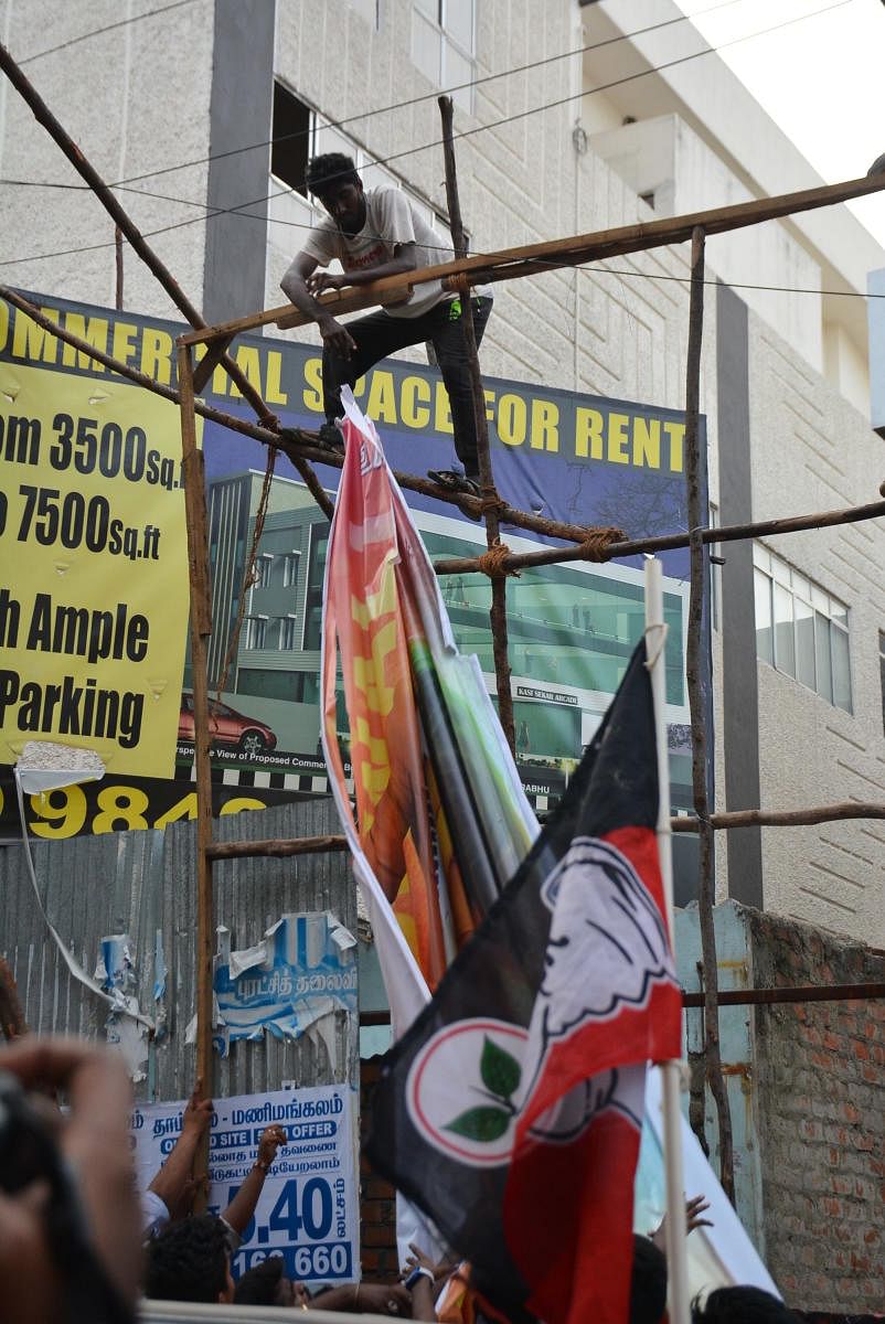 AIADMK cadre tearing the banner of actor Vijay's Sarkar at Kasi Theatre in Chennai. DH photo