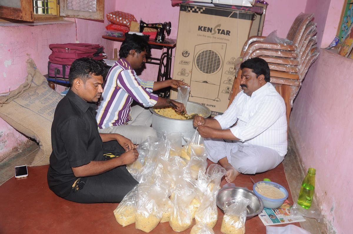 hands that serve: Purushottam and others packing food at Y N Hoskote.