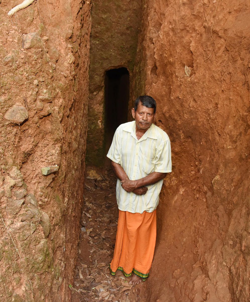 Mahalinga Naik near the tunnel he had dug. DH Photo 