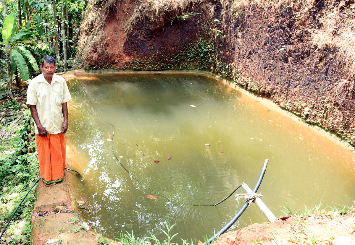Mahalinga Naik near a water tank that stores water from the tunnel. DH Photo 