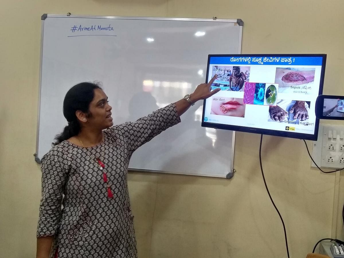 Teacher explains science concepts using Kannada titles using a visual medium. 