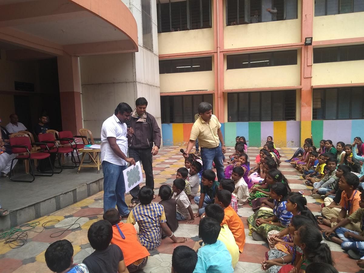 Teacher instructing students in Kannada on science topics. 