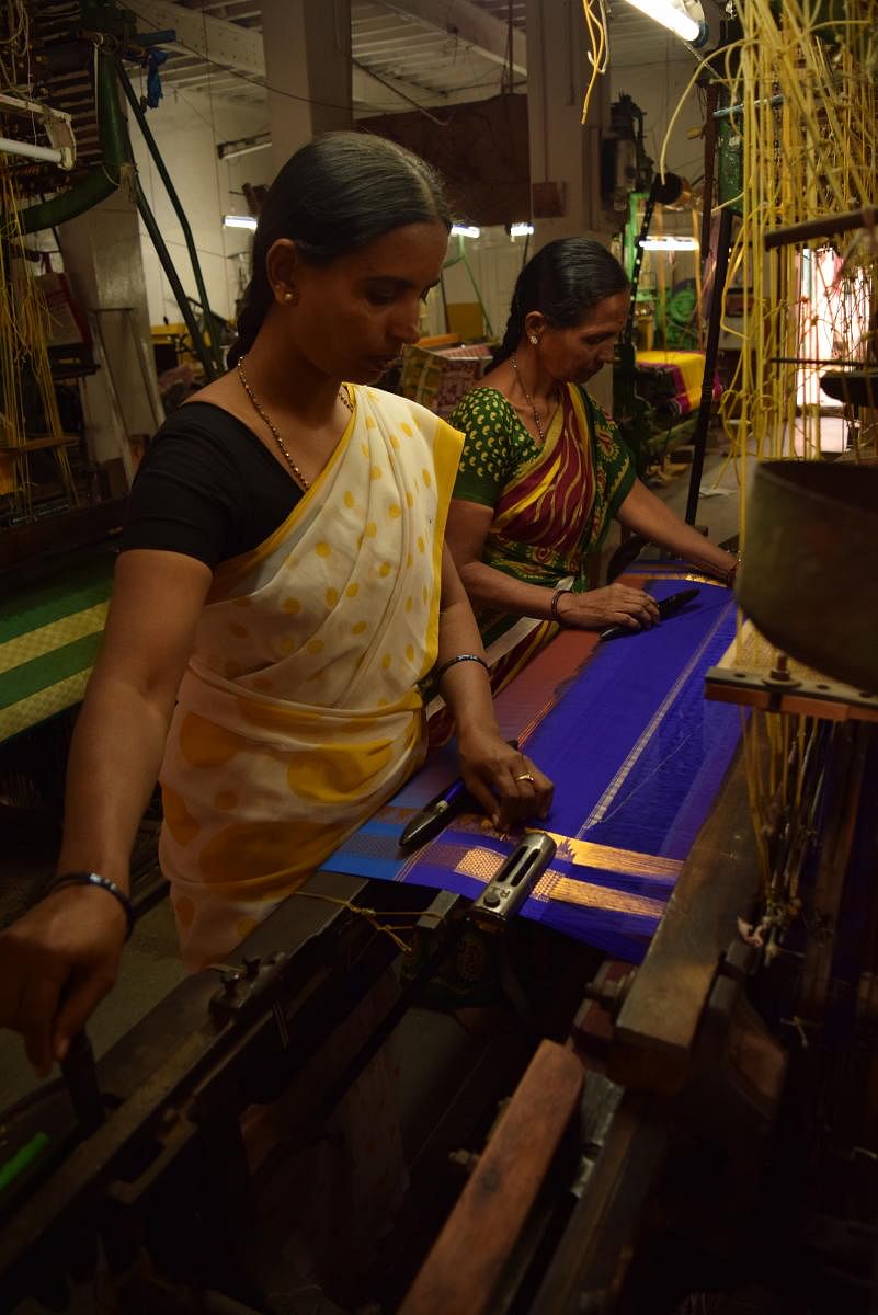Women folk in weaving process at a handloom.