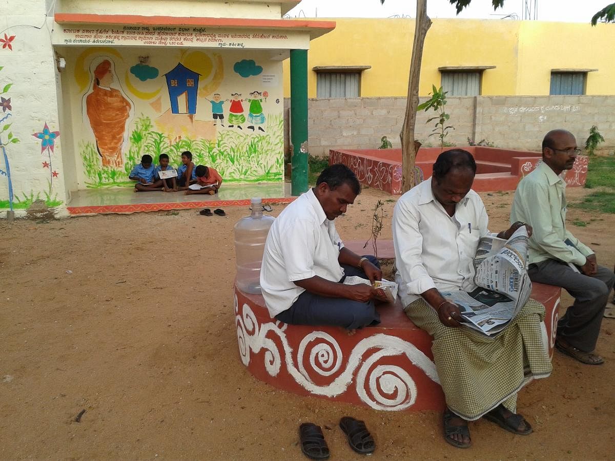 Villagers reading news papers in library campus.