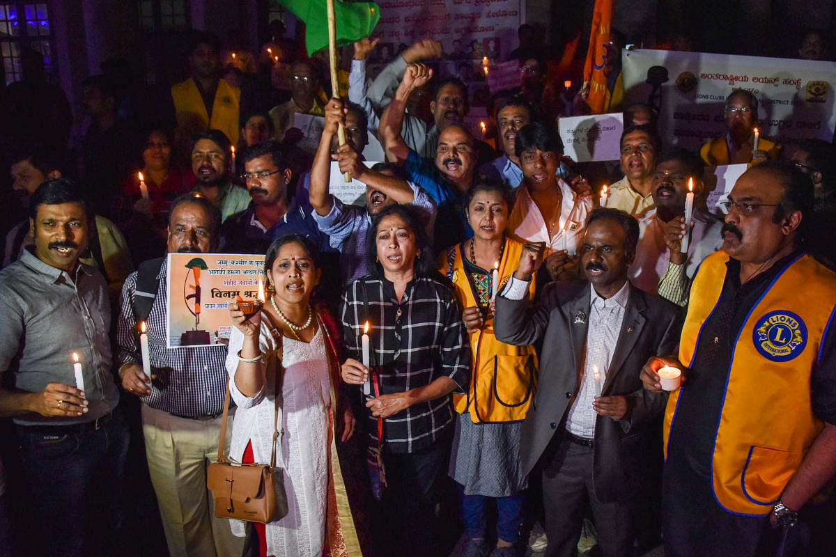 Members of various organisation stage a candlelight protest in front of Town Hall on Friday against the terrorists attack on Central Reserve Police Force personnel in Pulwama. DH photo/S K Dinesh
