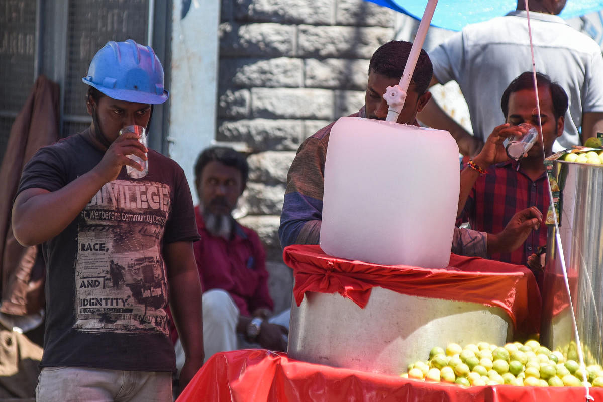 People drinking lemon juice to beet the heat at SJP road in Bengaluru on Thursday. Photo by S K Dinesh