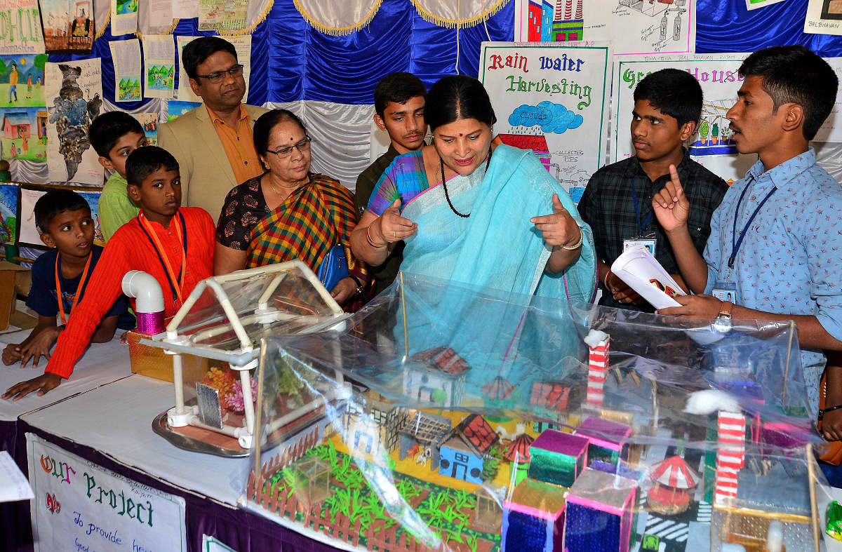 Jayamala, Minister for Women and Child Development looks at a model displayed by the students during the inauguration of 27th Young Environment Camp at the Bala Bhavan on Monday. DH Photo/Ranju P