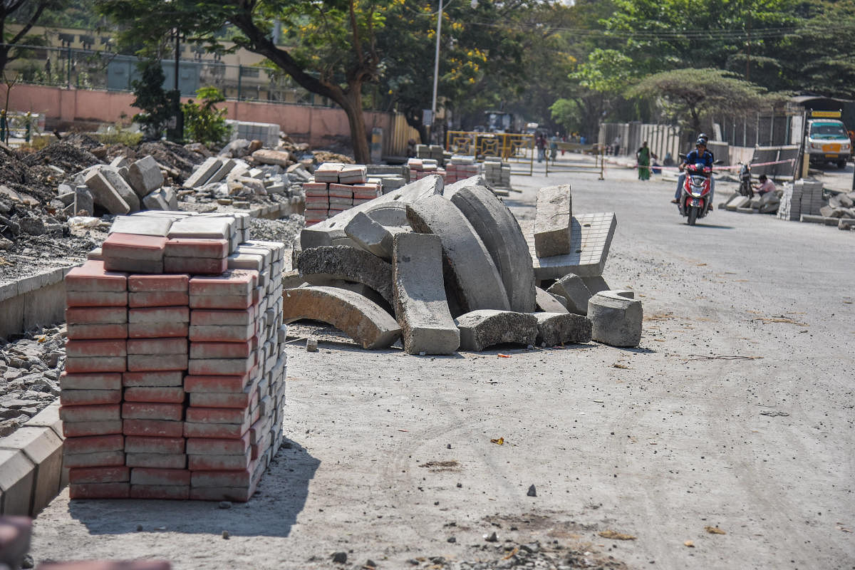 Construction materials kept on the road have made things worse. DH PHOTO/S K DINESH