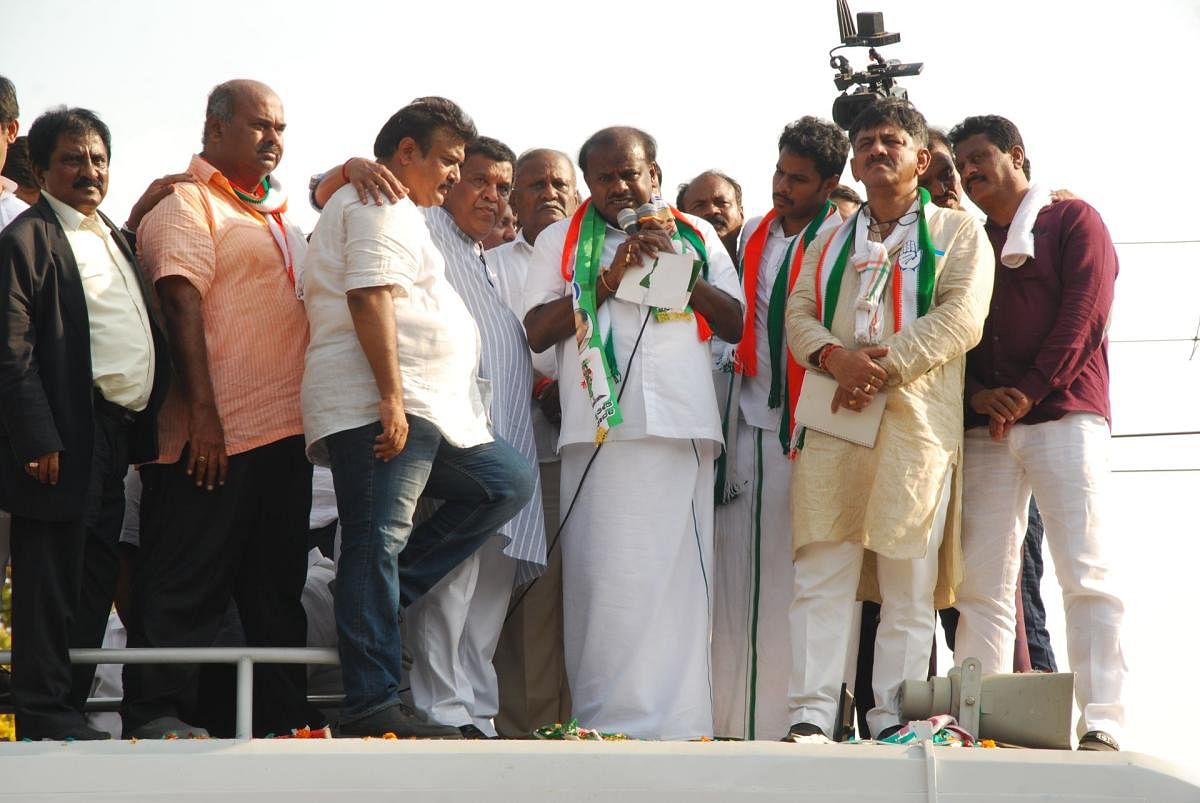 Hundreds of JD(S) workers take part in a procession with their candidate Nikhil Kumaraswamy in Mandya on Monday while he was on his way to file nomination papers. (Right) Chief Minister H D Kumaraswamy addresses JD(S) and Congress workers. DH photo