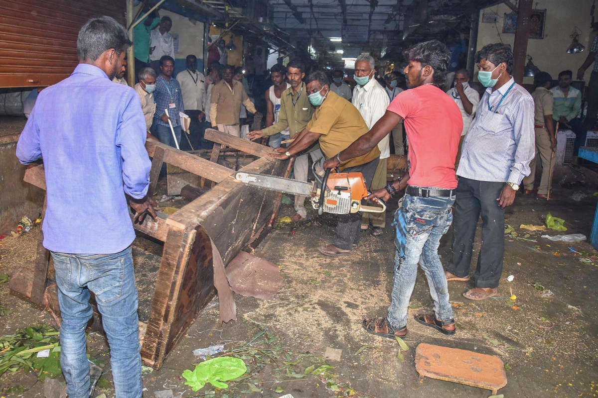 BBMP workers dismantle a table that put up in the KR Market passage to display merchandised. DH PHOTO/S K DINESH