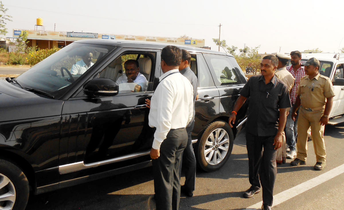 Officials on poll duty intercept Chief Minister H D Kumaraswamy's car, on the national highway 75, at Hirisave, Hassan district, on Wednesday.