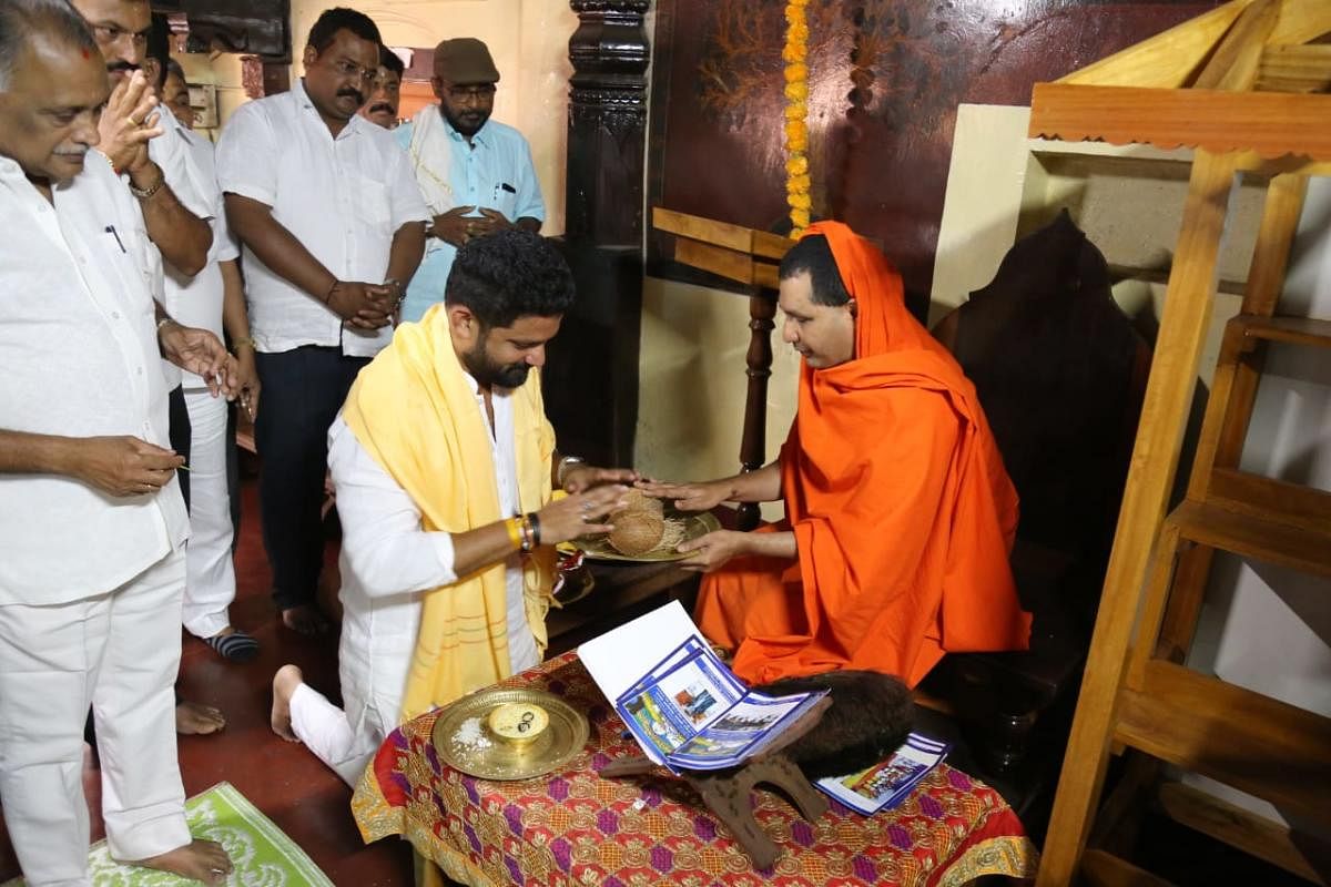 Congress-JD(S) candidate Mithun Rai seeks blessings of Jain seer Charukeerthi Bhattaraka at Moodbidri.