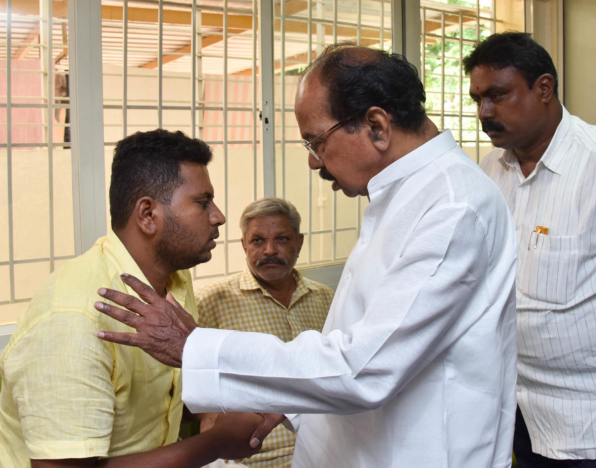 Congress leader Veerappa Moily consoling Chetan, son of KG Hanumantharayappa, JDS Worker, who died in the serial blasts in Srilanka , people gathered outside the house of KG Hanumantharayappa at T Dasarahalli, in Bengaluru on Monday. Photo/ B H Shivakumar