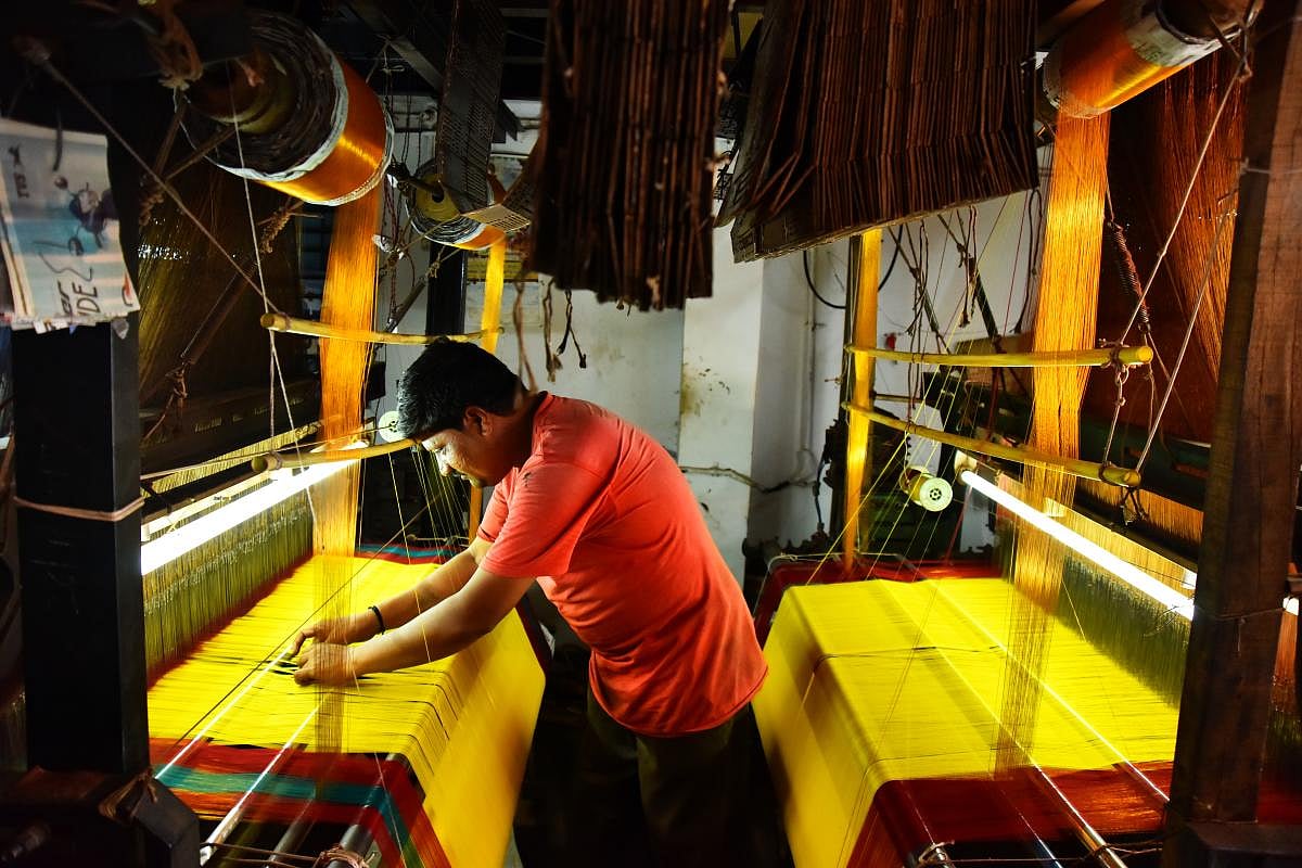 Talent and charm Handloom weavers weaving sarees in a pit loom in the Dharwad-Hubbali districts.