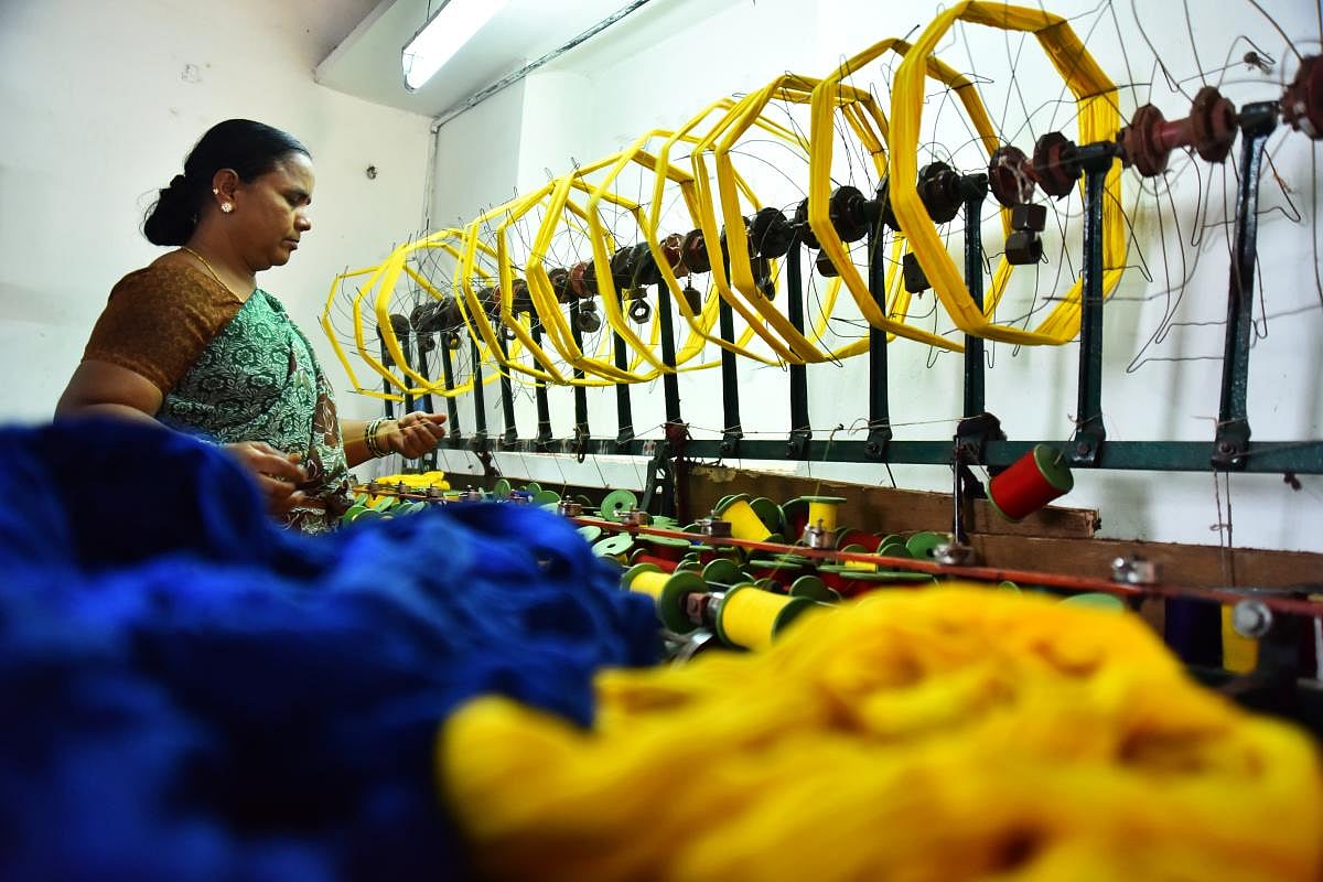 Talent and charm Handloom weavers weaving sarees in a pit loom in the Dharwad-Hubbali districts.