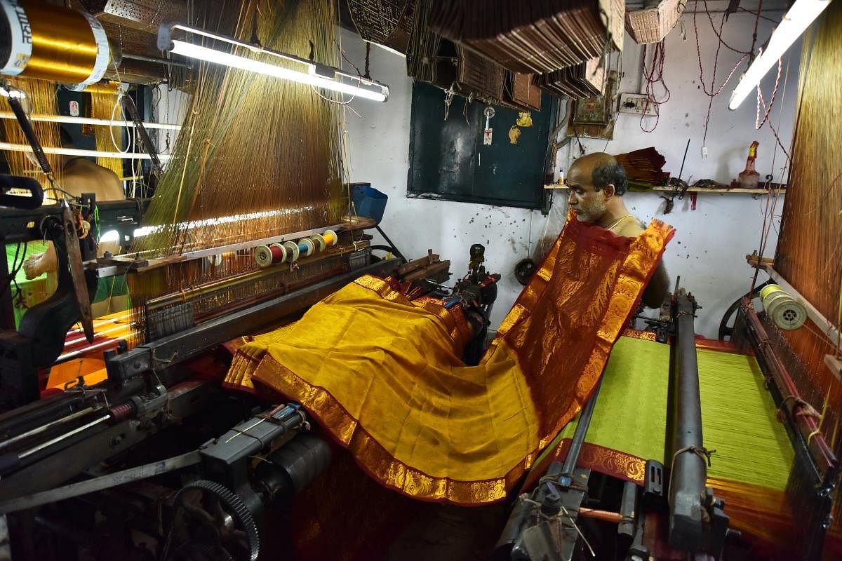 Talent and charm Handloom weavers weaving sarees in a pit loom in the Dharwad-Hubbali districts.