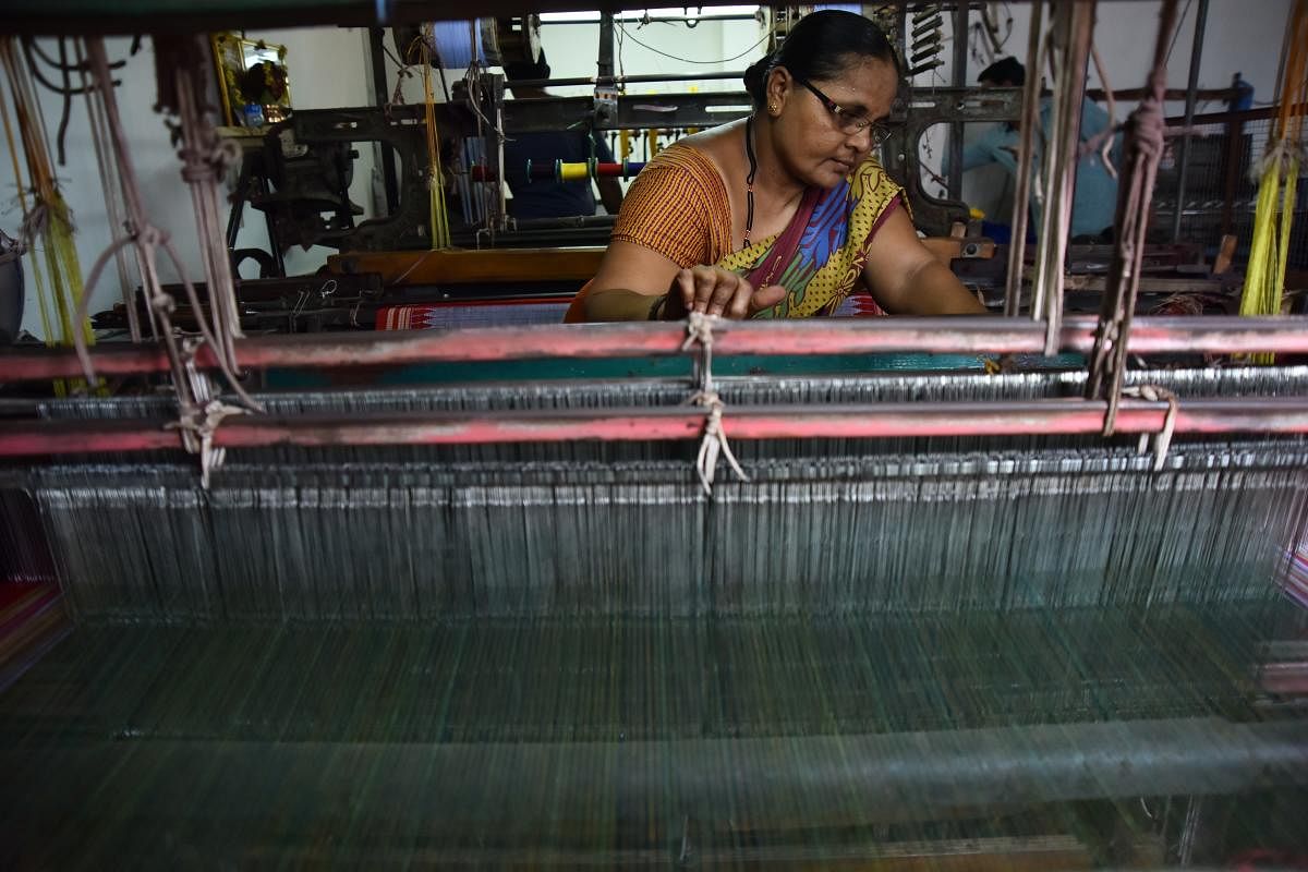 Talent and charm Handloom weavers weaving sarees in a pit loom in the Dharwad-Hubbali districts.