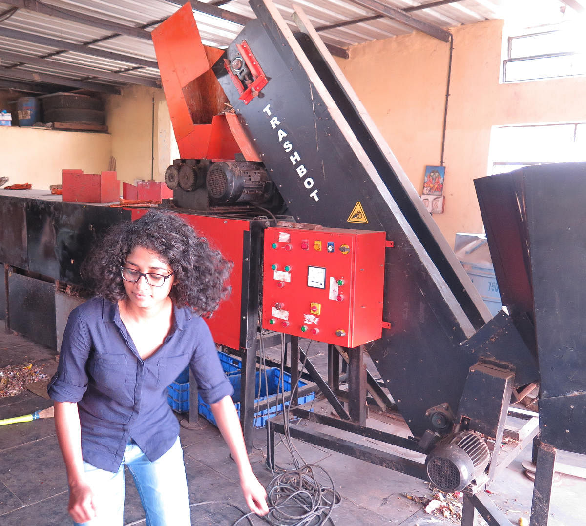Aishwarya K, Operations Manager for TrashCon, works in front of a 1-ton TrashBot waste segregation machine installed at a BBMP waste collection centre in Basavangudi, Bengaluru, on May 9, 2019. 