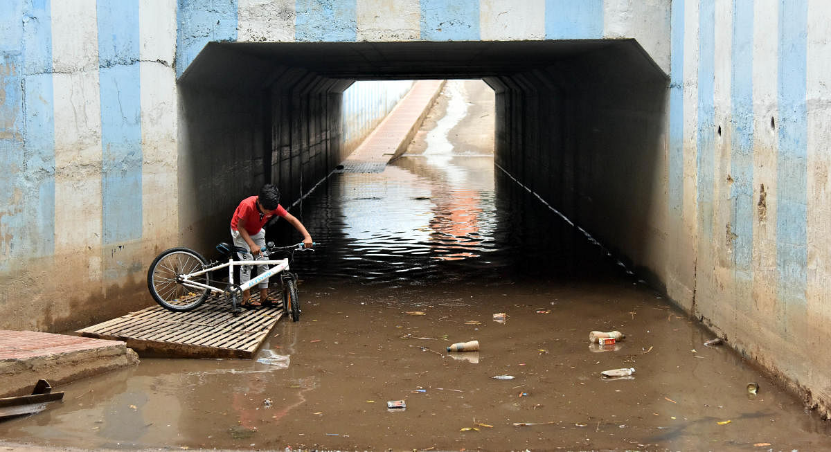 A young cyclist stuck in the flooded underpass at Muthyala Nagar near Mathikere.  