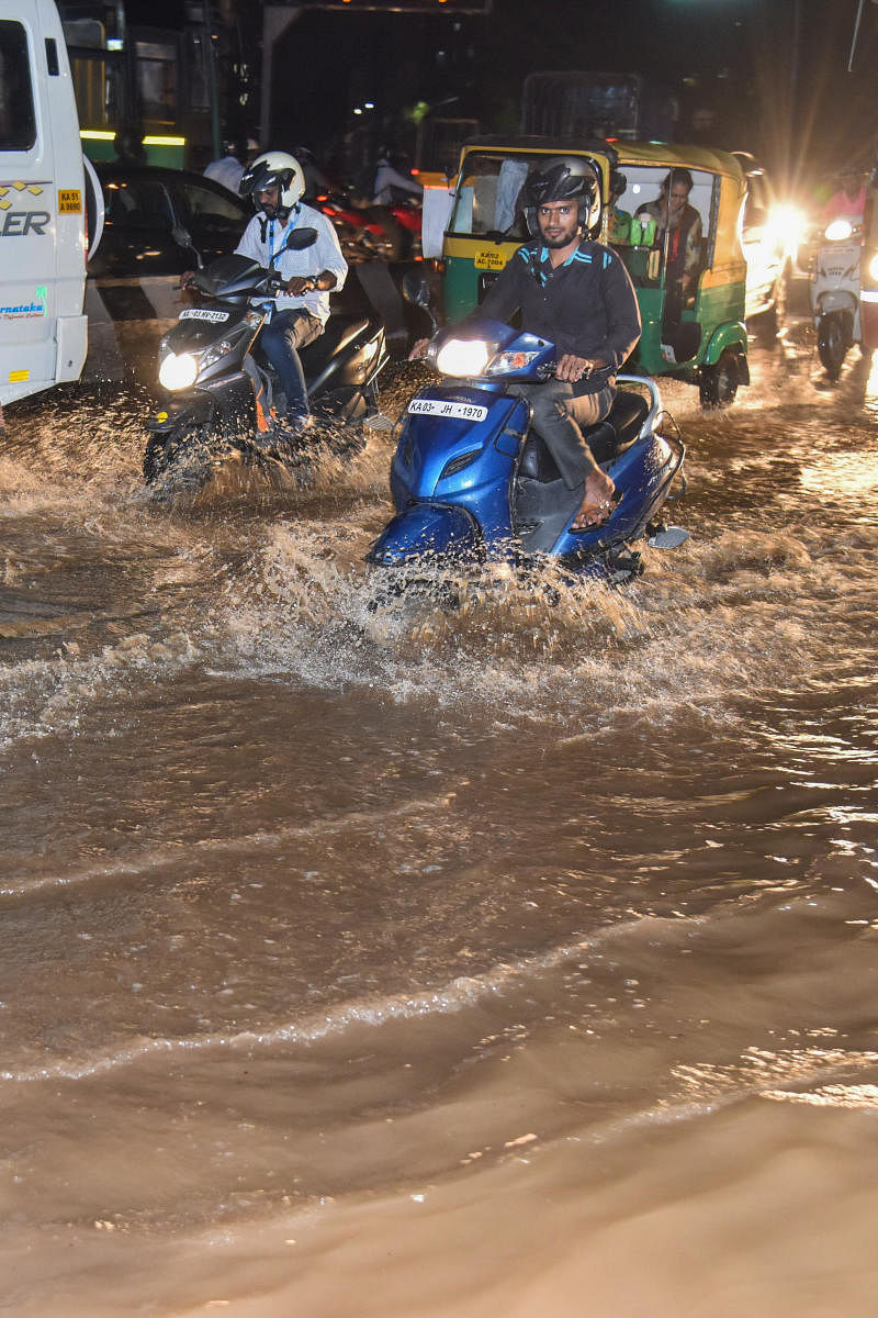 Motorist struggle on a waterlogged Queen's Circle in Bengaluru on Friday. DH PHOTO/S K Dinesh