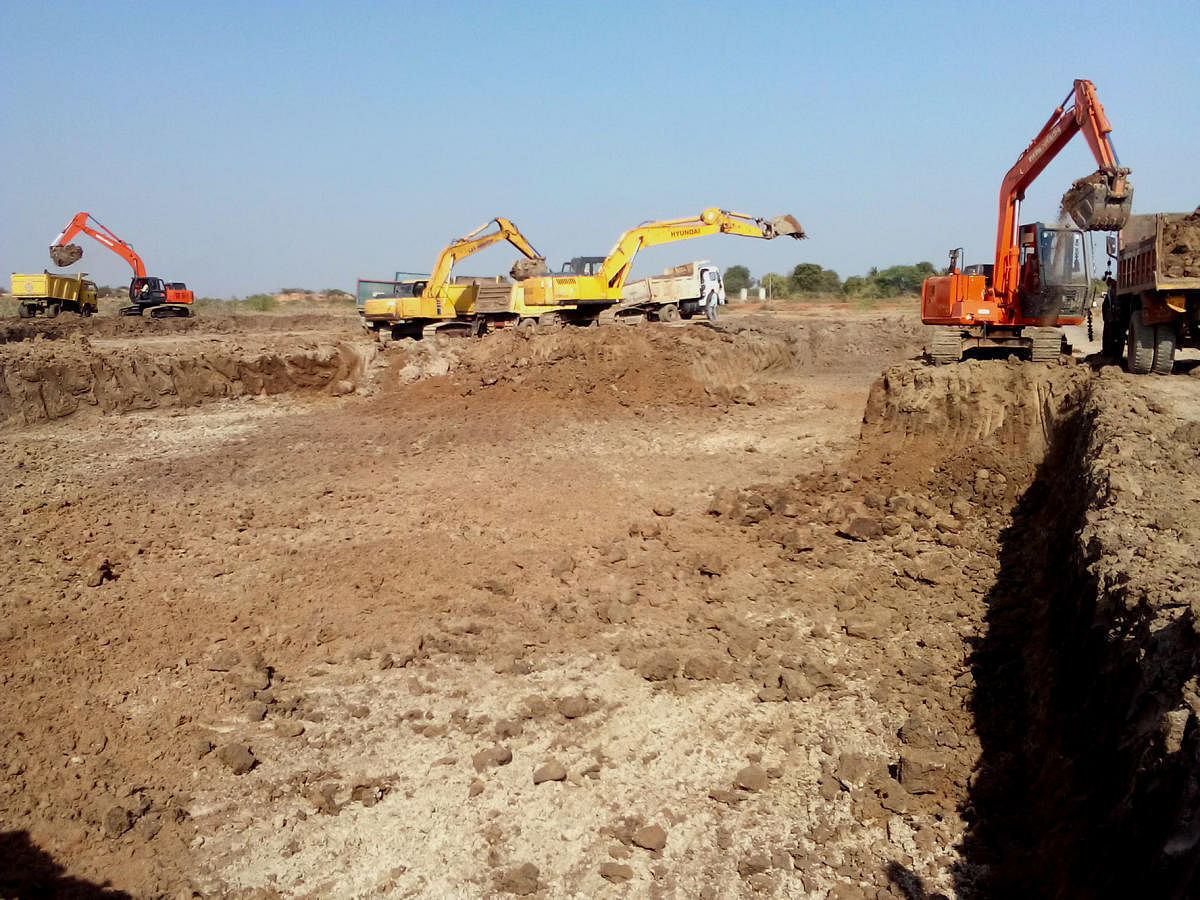 Progressing Revival work is underway at the Nidashesi lake near Kushtagi town in Koppal; villagers gathered at the project inauguration ceremony; a view of the parched lake; earth-moving machines in the desilting process.
